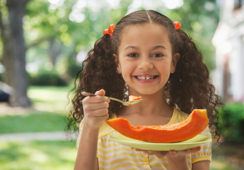 Niña comiendo frutabomba