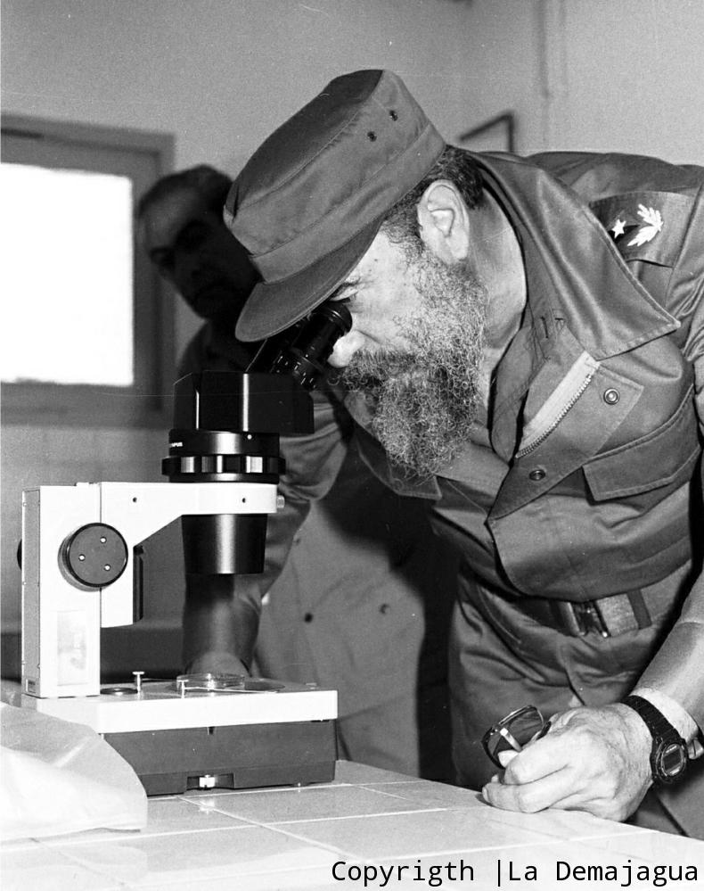 Fidel castro observa a través del microscopio.